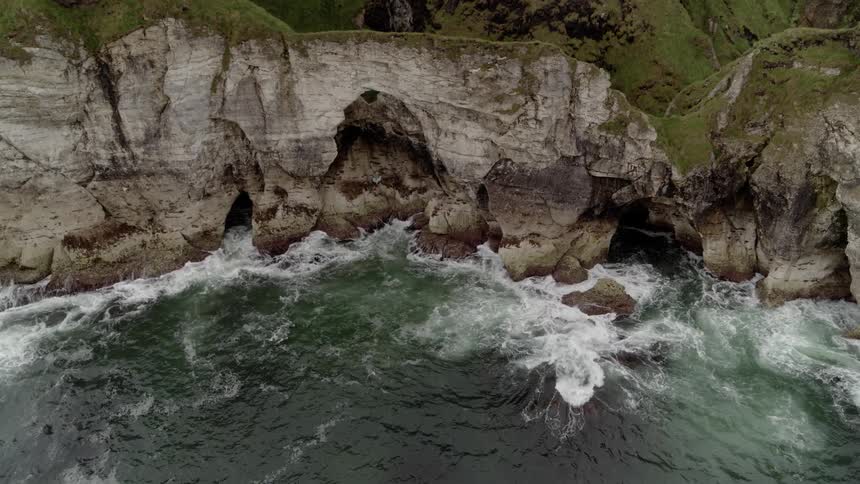 Waves crash against a cliff