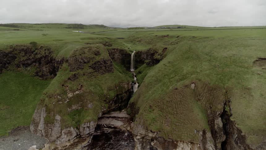Green waterfalls with the sky in the background