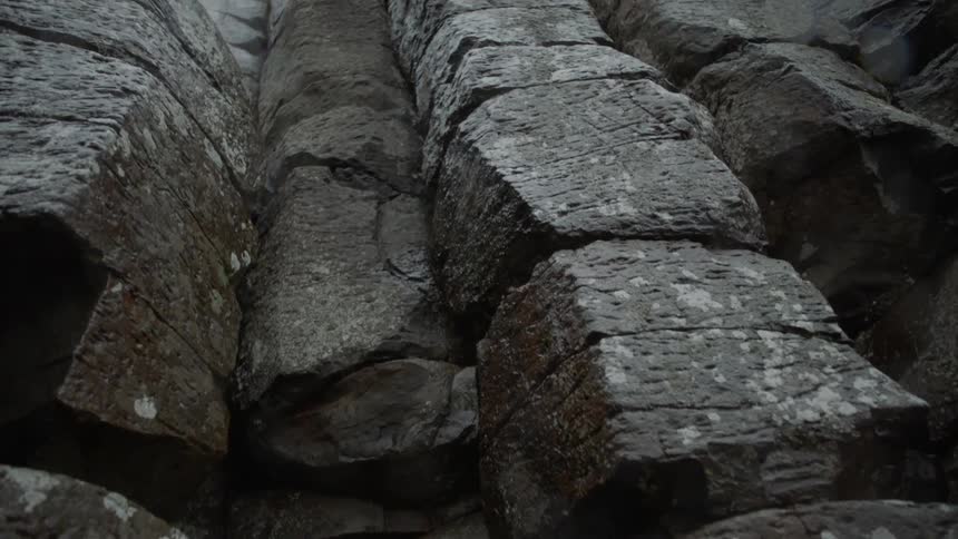 Looking up at a stone wall of stacked boulders