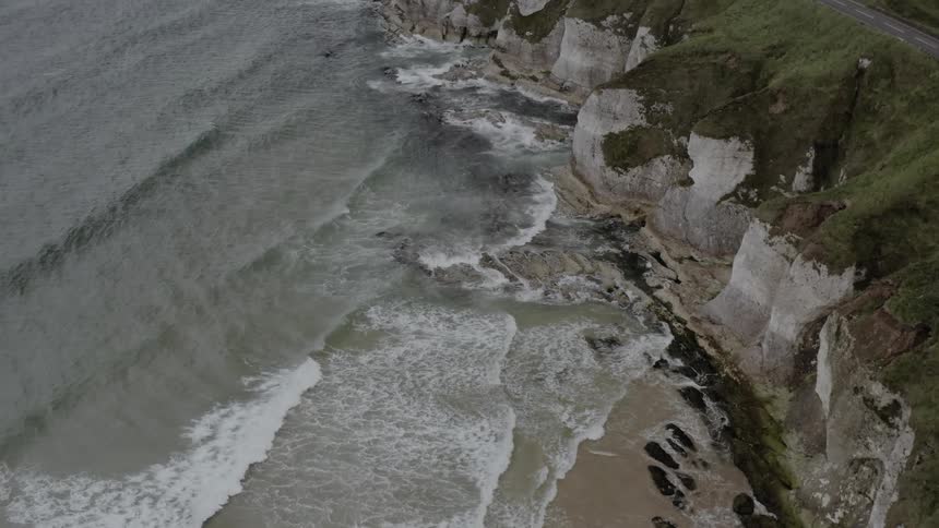 Ocean waves come to shore along rocky cliffs