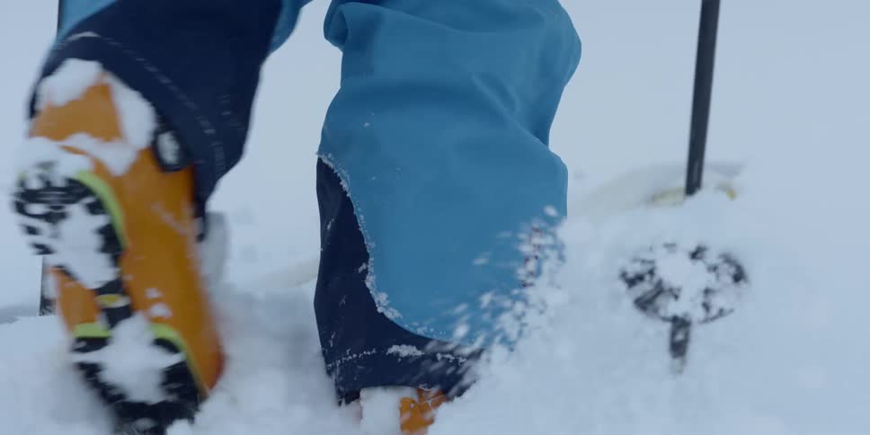 A man walking through the snow on skis