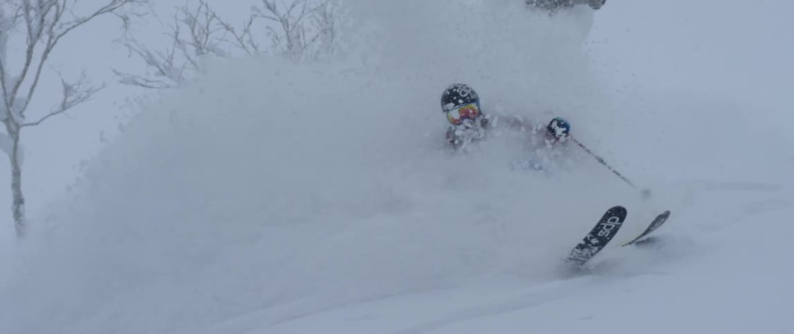 A person skiing in the snow with trees in the background