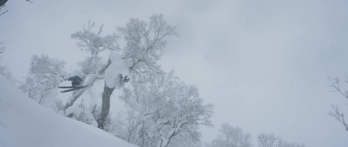 A person does a big jump on skis and falls down