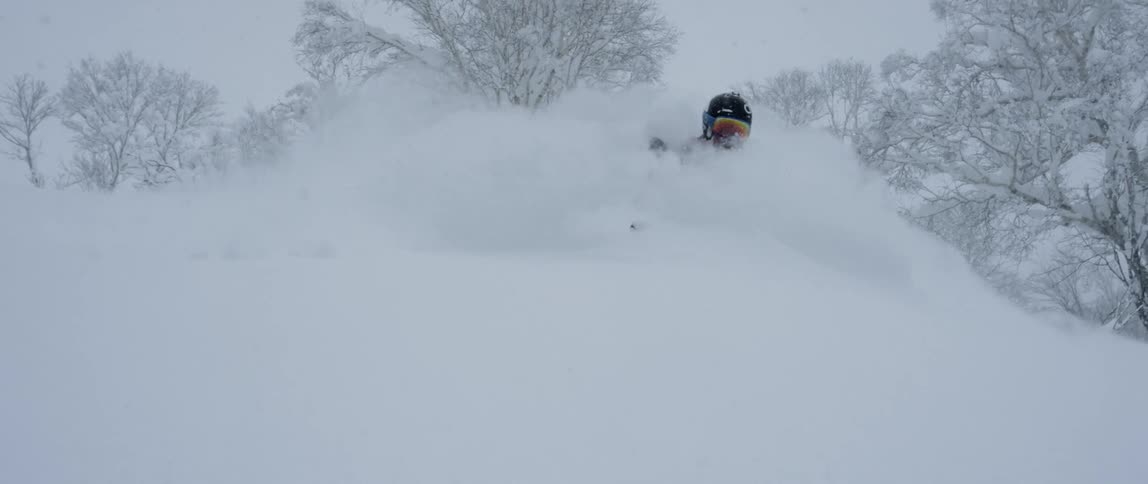 A person skiing in snow with helmet and goggles