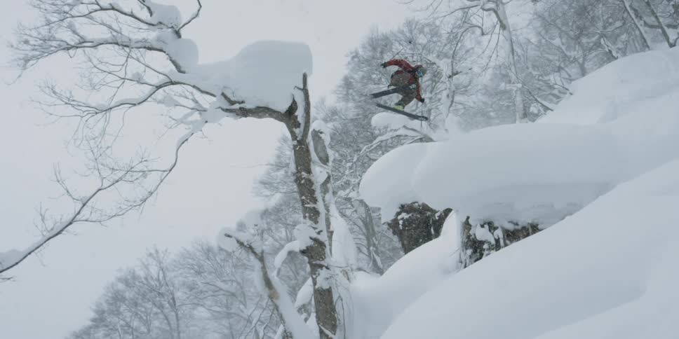 A person skiing on snow jumping and spinning