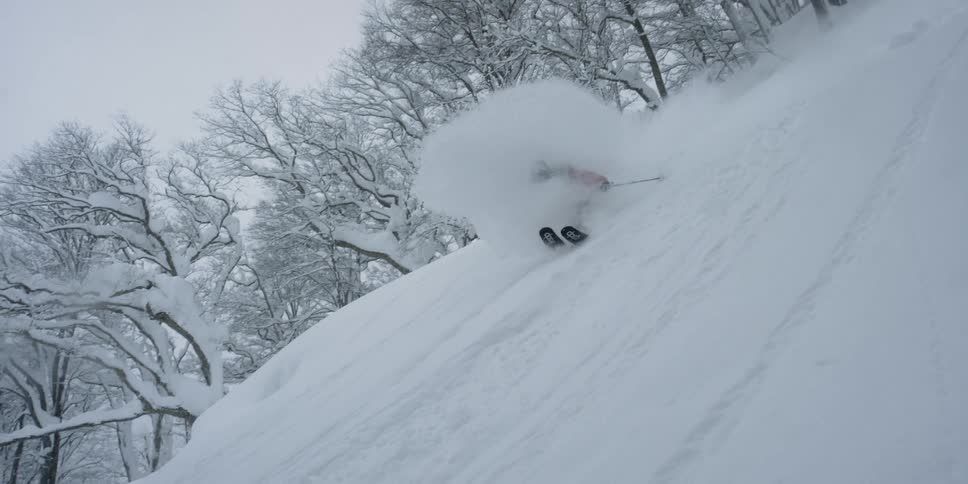 A skier zooms down a steep mountain slope