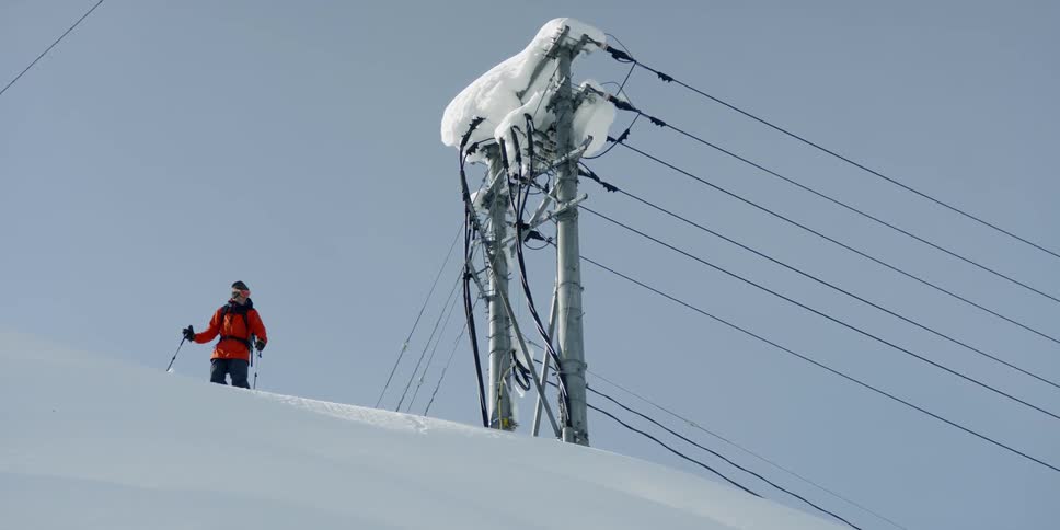 A man standing on top of a large snowdrift