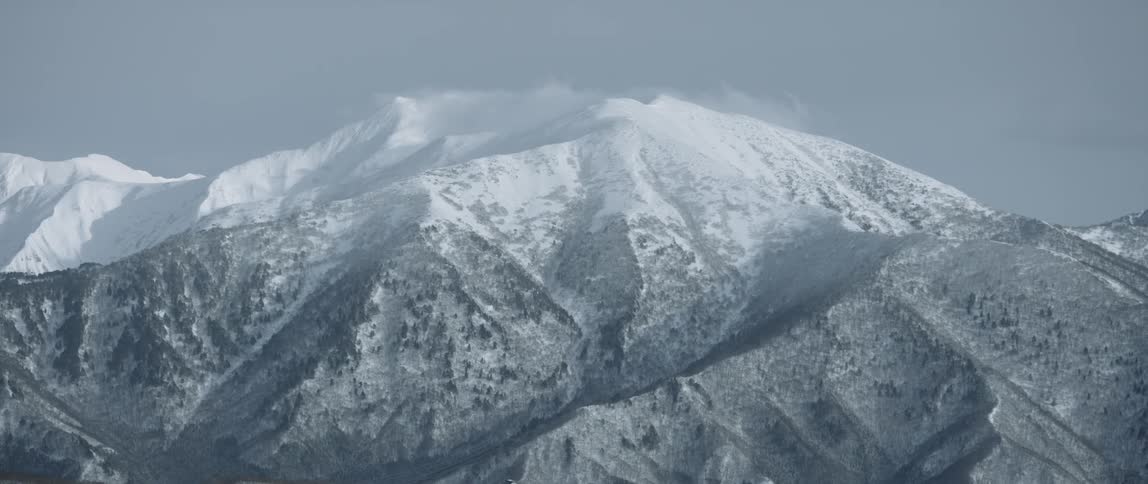 Snow covered mountains sit under a blue sky