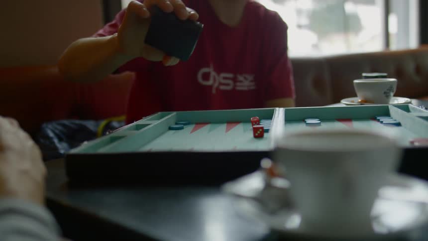 A man and boy play backgammon in a living room