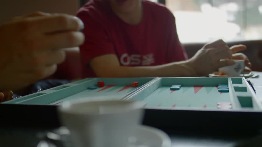 Two people playing backgammon at a table