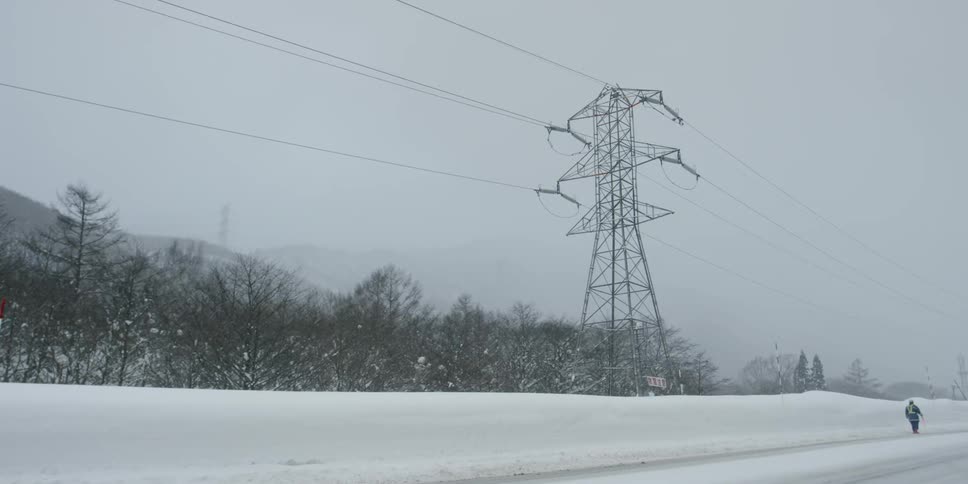 A person walks down a snowy road
