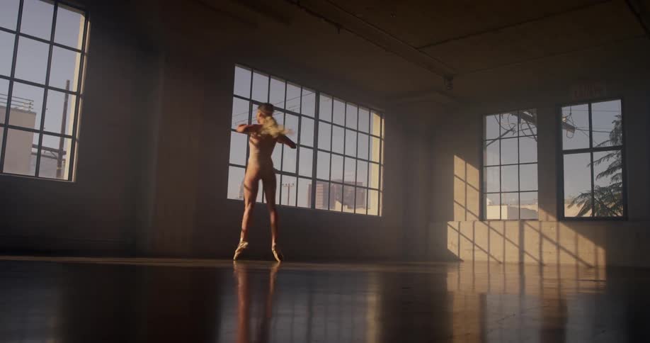 Ballet dancer twirls across floor in dance studio