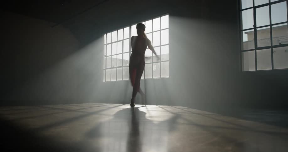 A young ballerinapracticing in a dim room