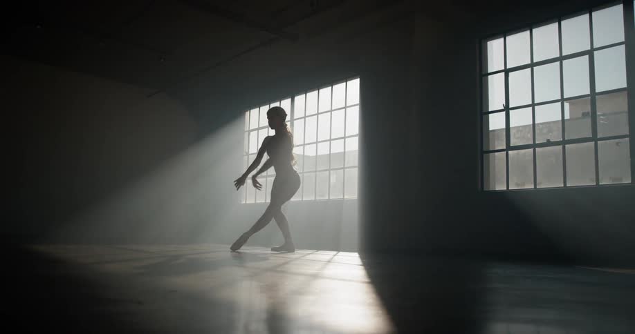 A woman in a dance studio dancing and twirling