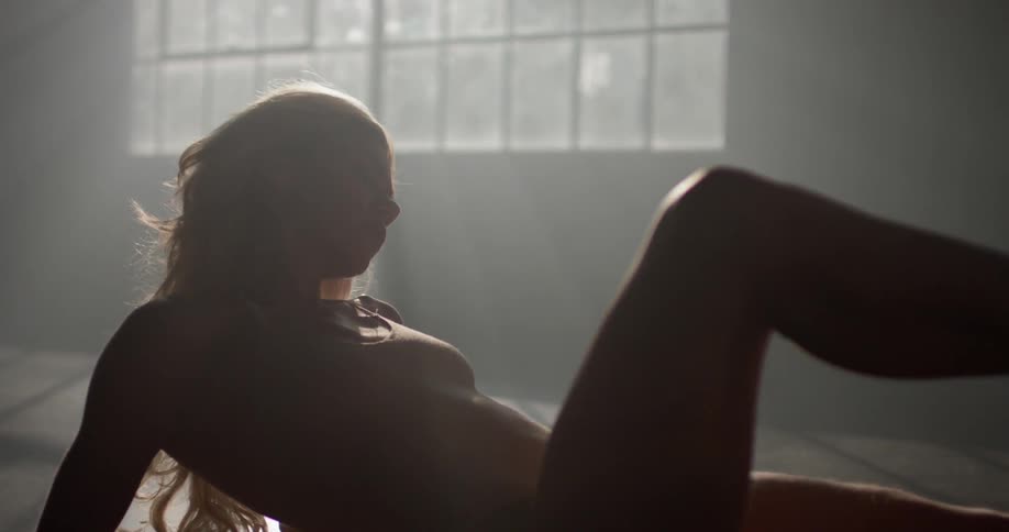 Ballet dancer sits on floor and moves legs gracefully