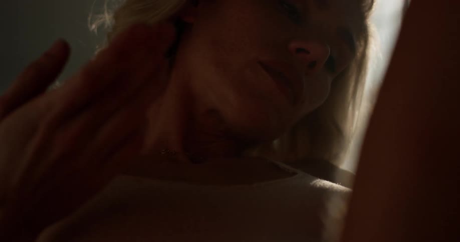 A woman in a bodysuit stretches in room with a georgian window letting in the morning sun