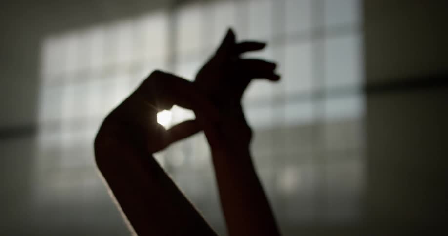 A woman moves her hands and fingers in rhythmic patterns