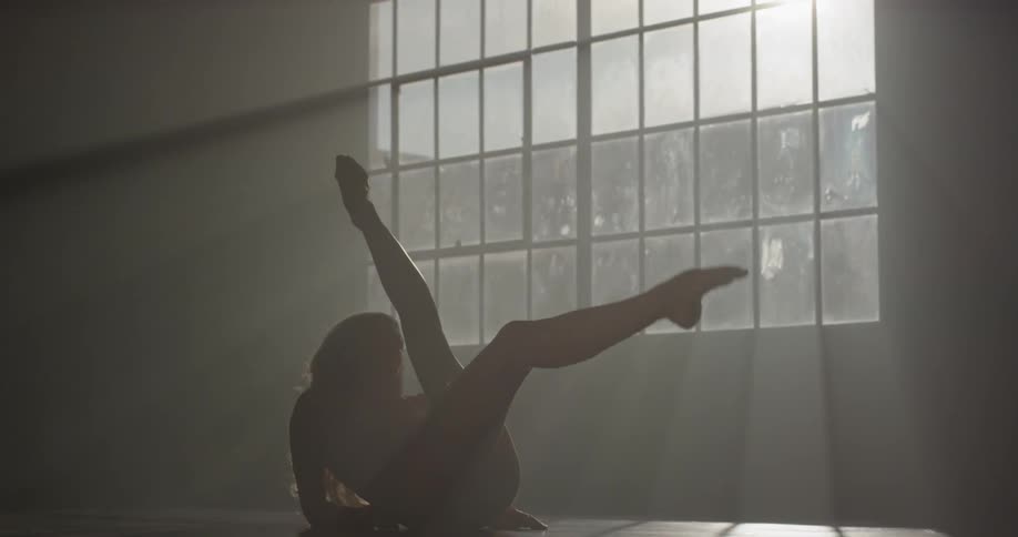 A dancer stretches in a studio