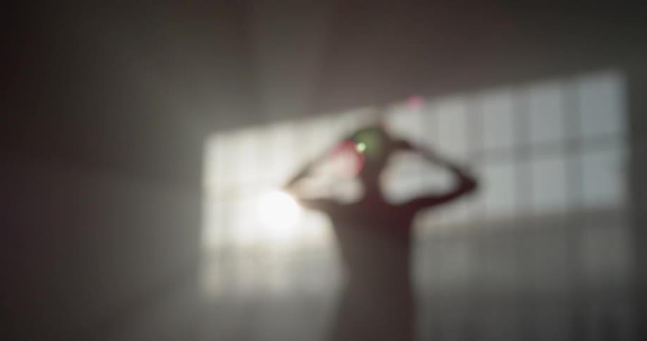 Out of focus person in dimly lit room