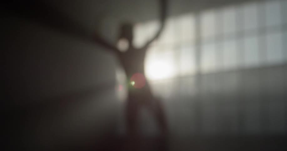 A woman flips spins and dances in a room by herself