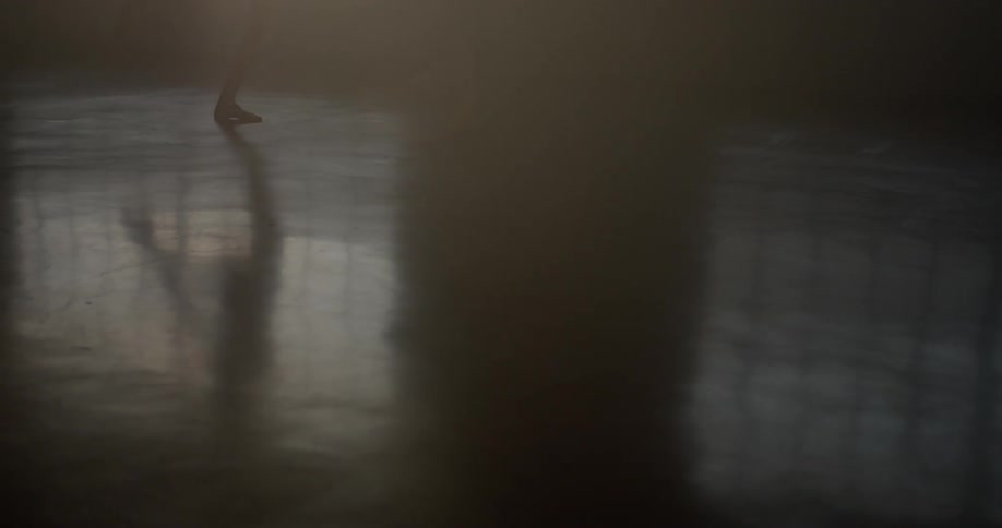 A young woman dances in a dark room