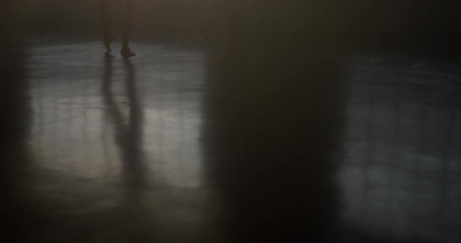 A dancers reflection on the studio floor as she twirls and poses near the windows