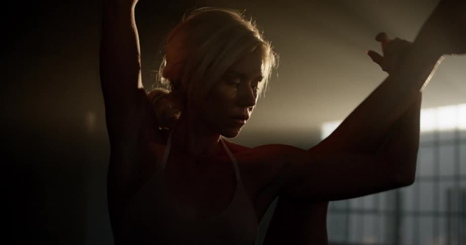 A woman dances in a dark room