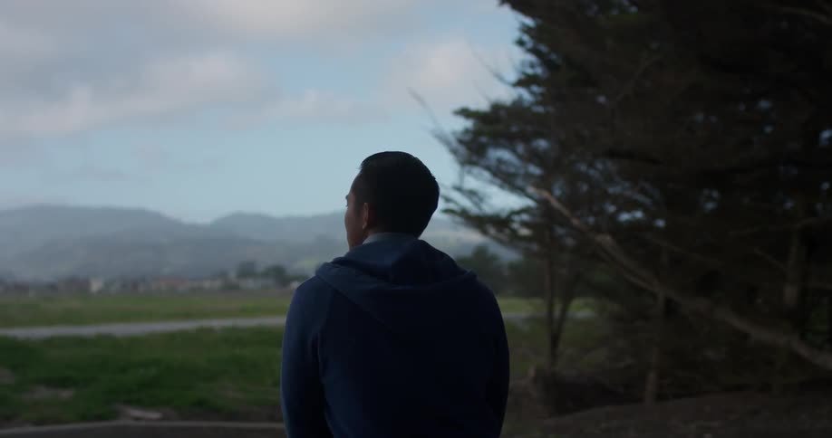 A young man sits and looks in to the distance