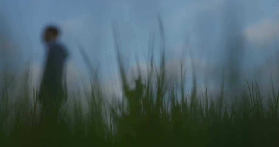A man walks across a grassy field