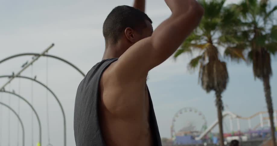 A man stands outside and stretches