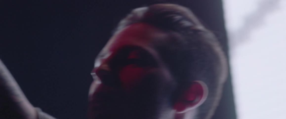 A man with short hair waves his arms around and dances