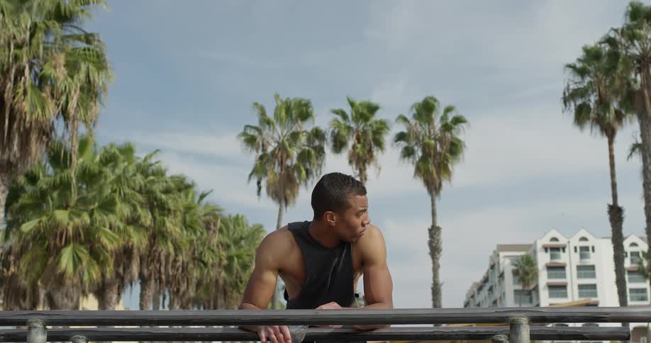 Man resting elbows on handrail while drinking water
