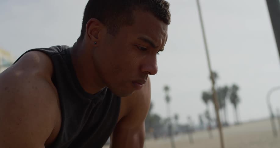 Sweaty man on a beach resting after exercise
