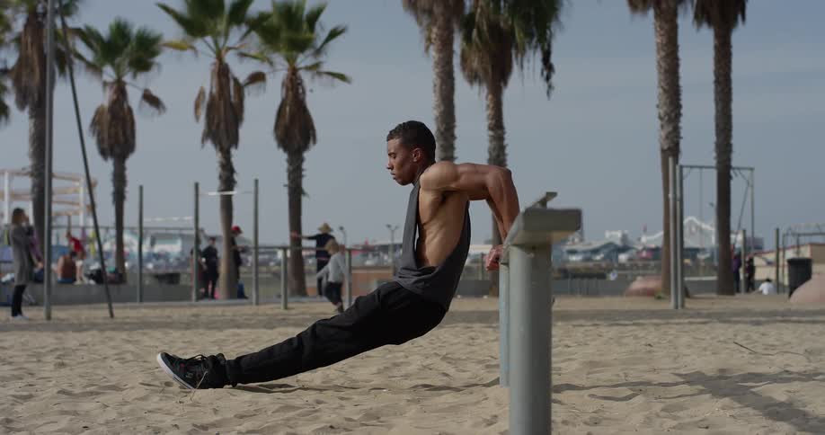 Man stretches as he leans back against a post