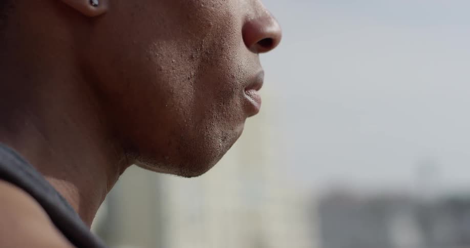 A black man drinking from a bottle of water