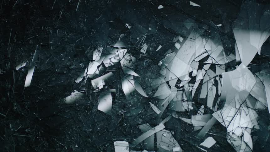 An overhead view of a thick layer of glass shards reflecting moving lights above