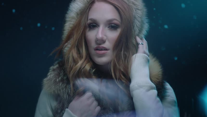A blonde woman looking around in snowfall