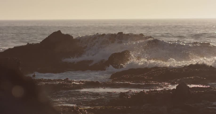 Waves crashing over large rock formations on the coast