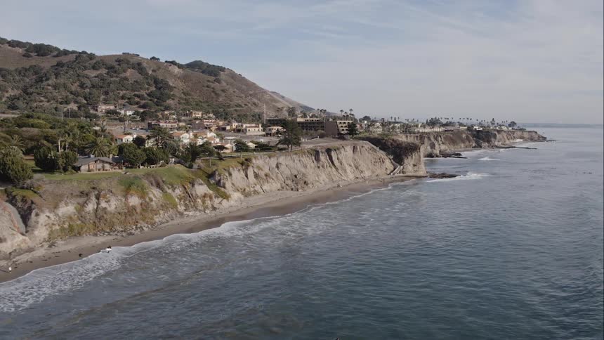 Houses sit just off a coastal cliff