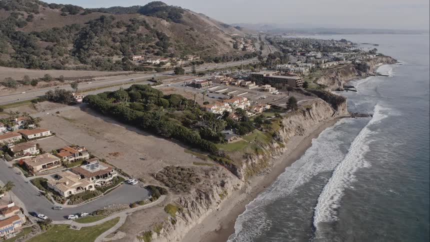 Skyline view with waves going towards the shore and neighborhoods above the cliff