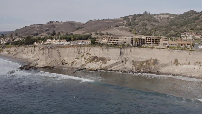 Buildings and homes sit on a coastline cliff