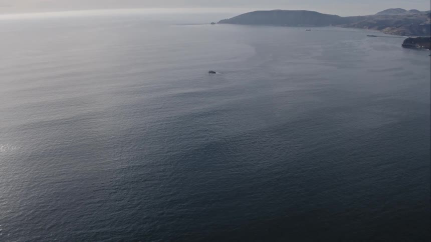 A calm ocean with a rocky coast