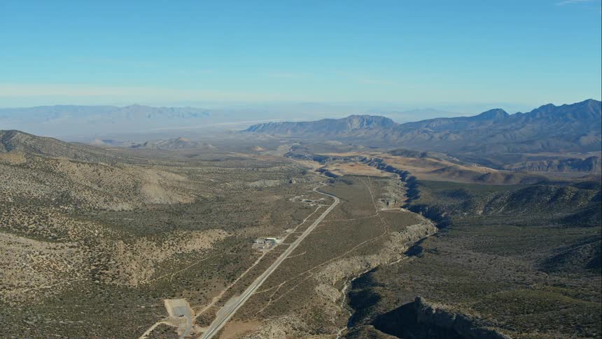 A long road with mountains and the sky in the background