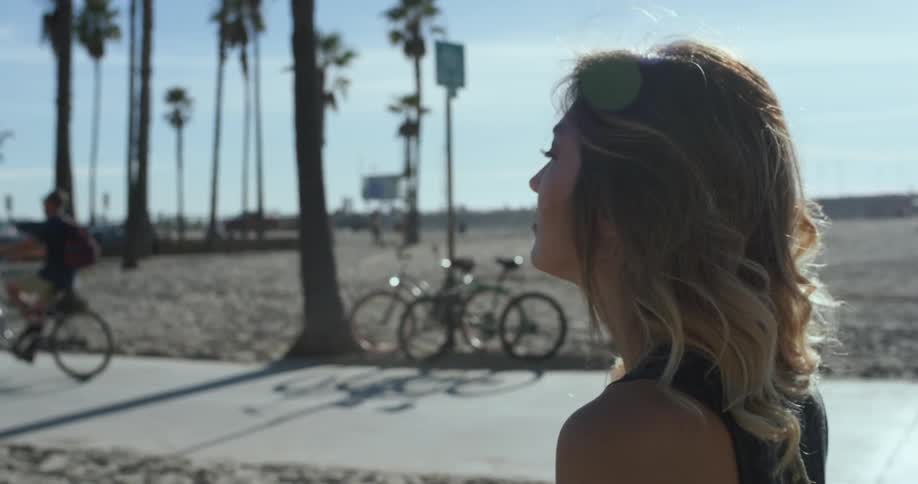 A woman walking next to a bike path on a beach
