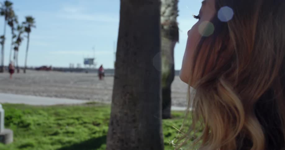 A woman walks on a patch near a beach