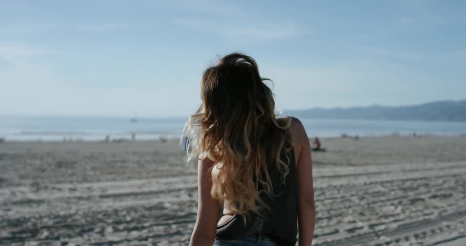 A woman looks around on the beach