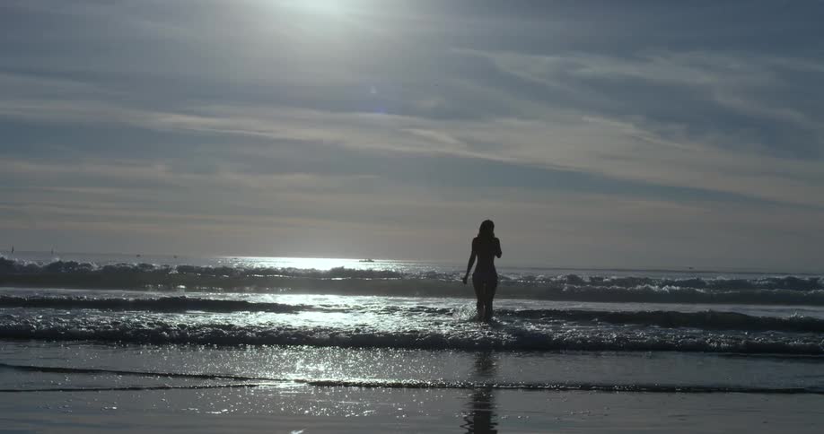 Woman walking on the waves of a beach