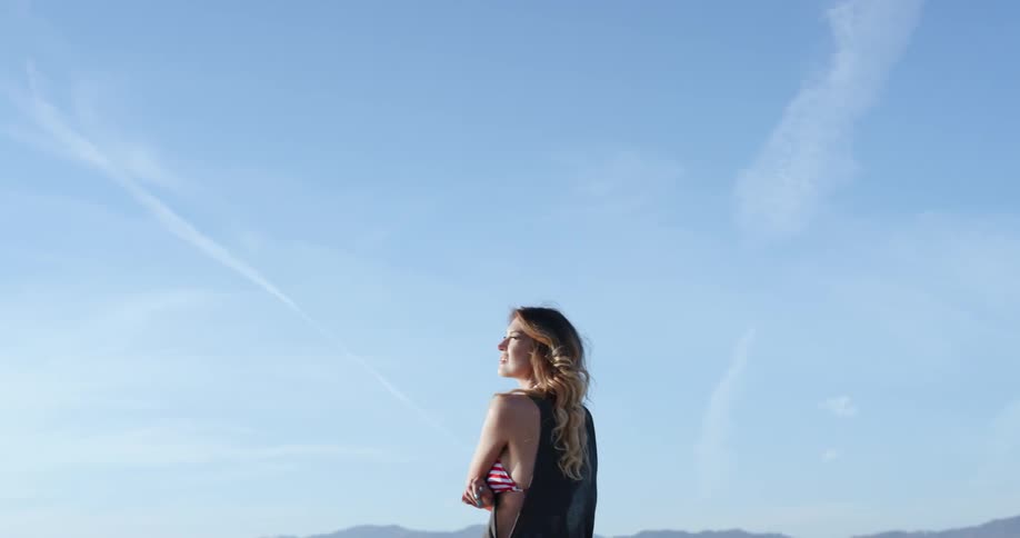 A white woman walks outdoors and looks around her