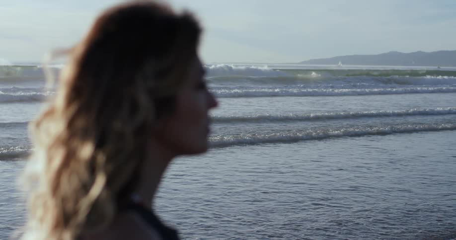 Woman standing on beach looking at horizon