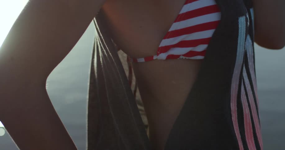 A woman is wearing a bikini on a windy day